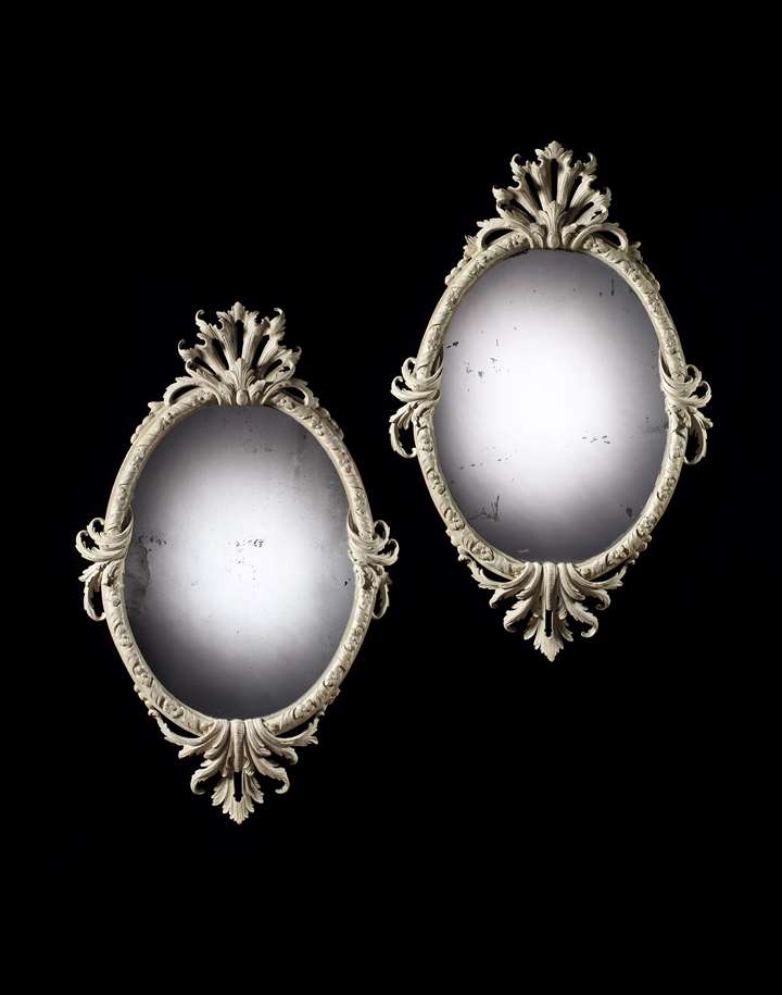 A PAIR OF GEORGE II PAINTED OVAL MIRRORS